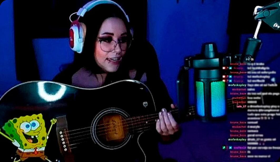 Registro de uma live: a streamer toca violão diante da câmera, com o chat à direita e um personagem do Bob Esponja no canto inferior esquerdo